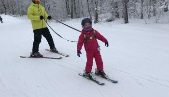 girl learning how to ski with dad