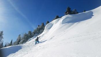 Excited Snowboarder by mound of snow 