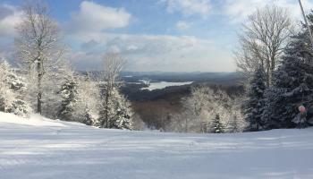 Snow-covered ski mountain with trees in the background